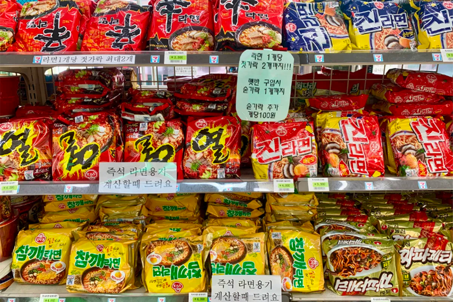 A vibrant display of instant ramen varieties on a convenience store shelf, showcasing Korean ramen brands and flavors.