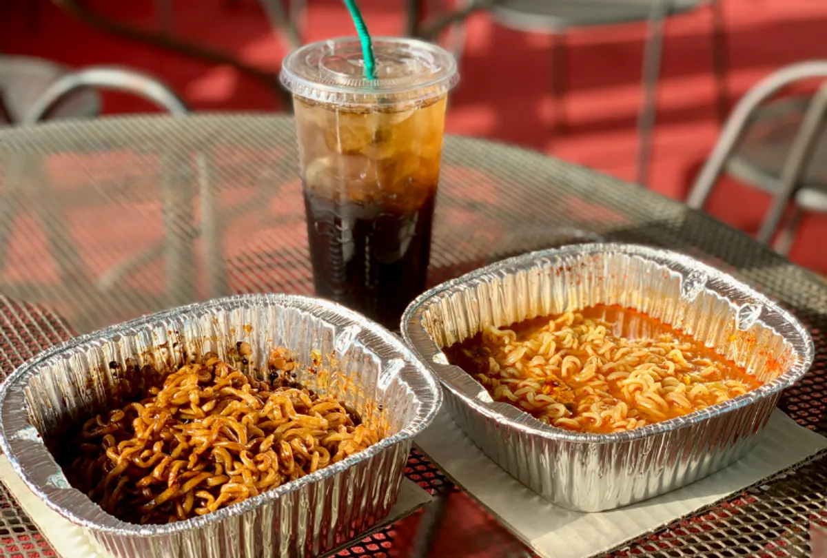 Ramen being served fresh and hot from the cooking machine, with steam rising and showcasing deliciousness.
