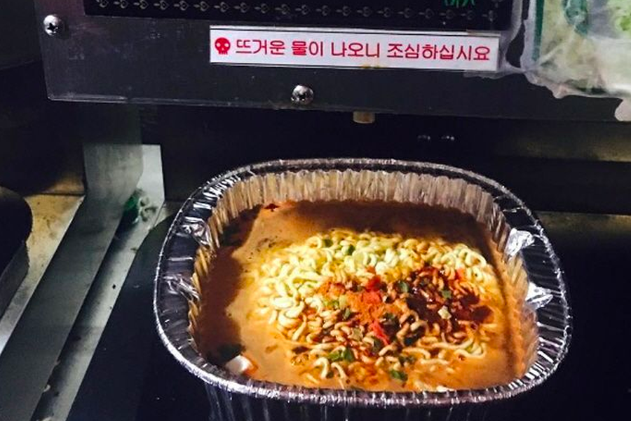 Finished ramen in an aluminum bowl, seasoned and garnished, ready to be enjoyed fresh from the cooking machine.