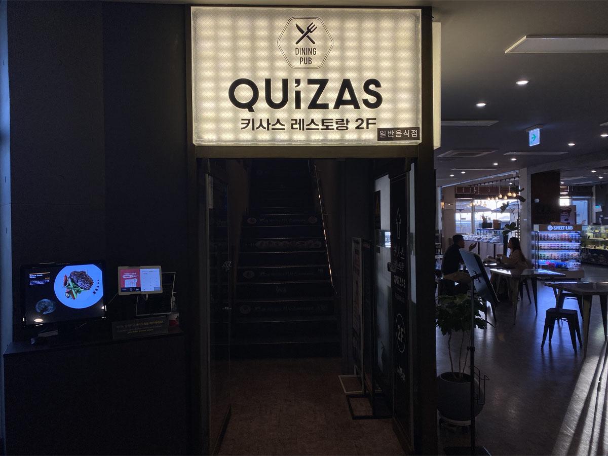 QUIZAS餐厅入口,位于仁川松岛著名的复合式艺文空间Caisson 24的二楼,提供多样化的餐饮选择。