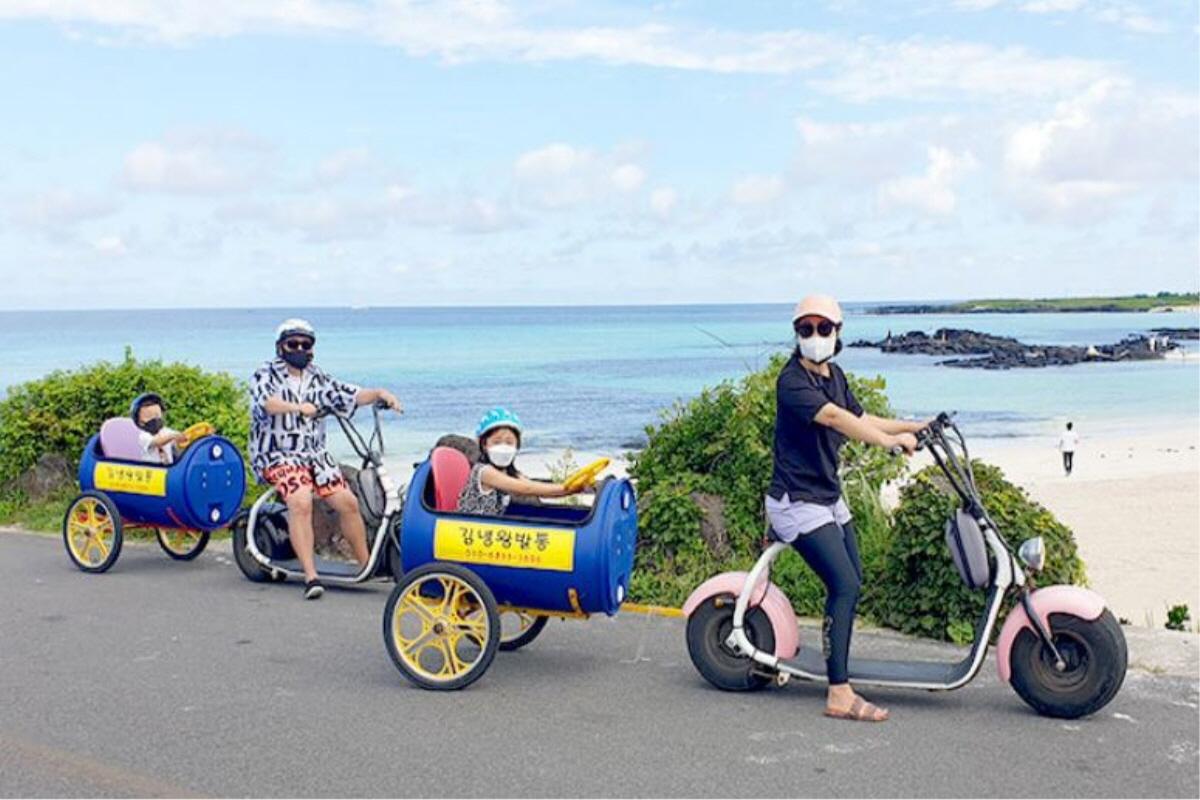 Familia disfrutando de bicicletas enlatadas en la carretera costera de Jeju, Corea del Sur