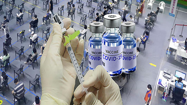 医务人员在疫苗接种点为接种者准备COVID-19疫苗，以推动第四剂疫苗接种工作。