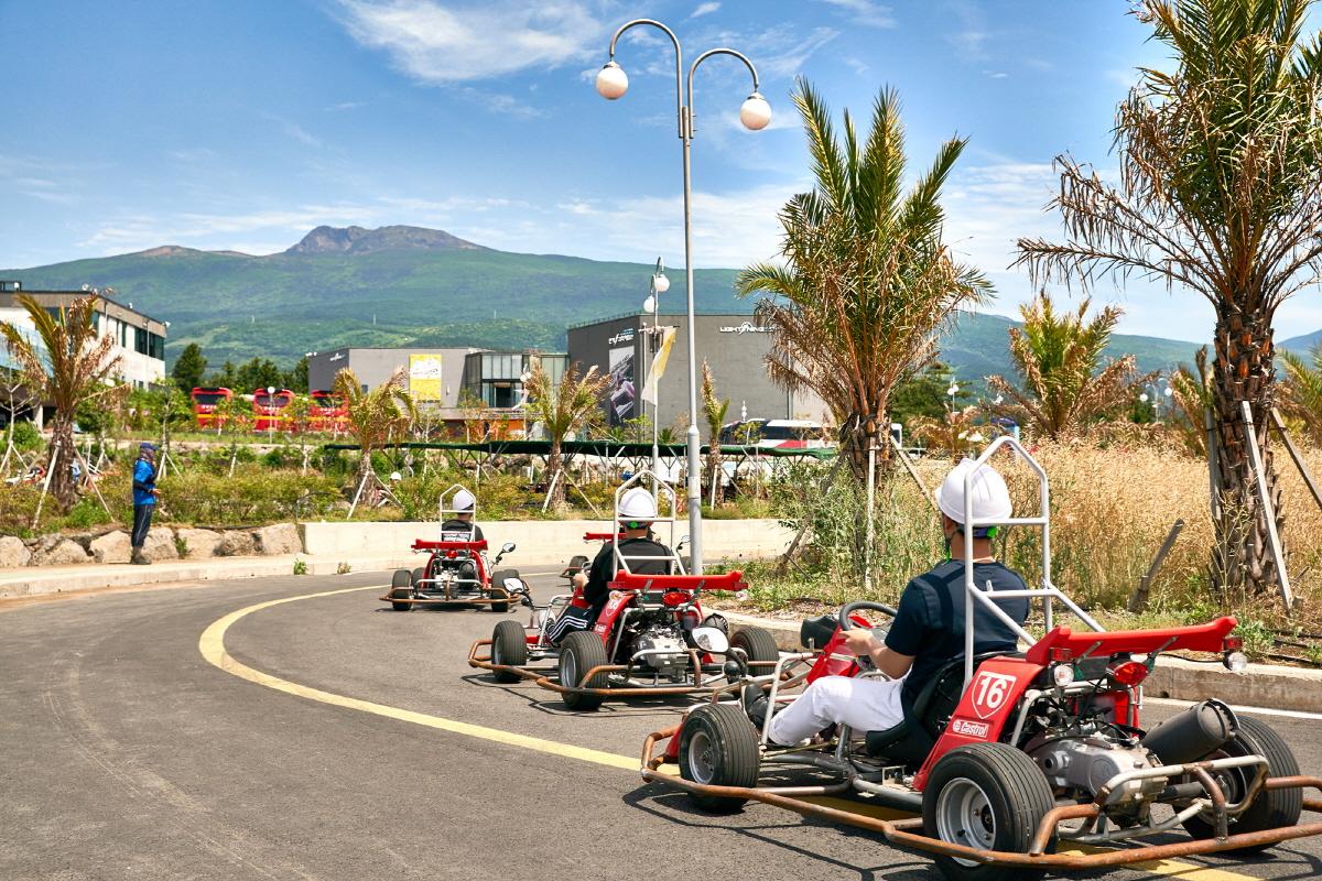 Renn-Karts in einer Schlange auf der Wind 1947 Strecke mit Blick auf die Natur von Jeju Island.