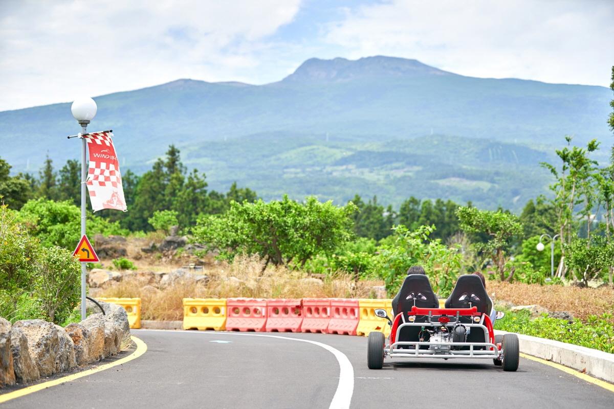 Ein Kart auf der Wind 1947 Strecke mit Mount Hallsan im Hintergrund, Jeju Island.
