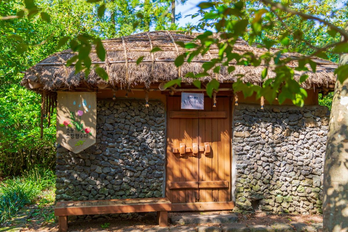 Жежү арлын Камеллиа Хилл хүрээлэнд галга амсар бүхий уламжлалт солонгос байшин, хана чулуун ашигласан.