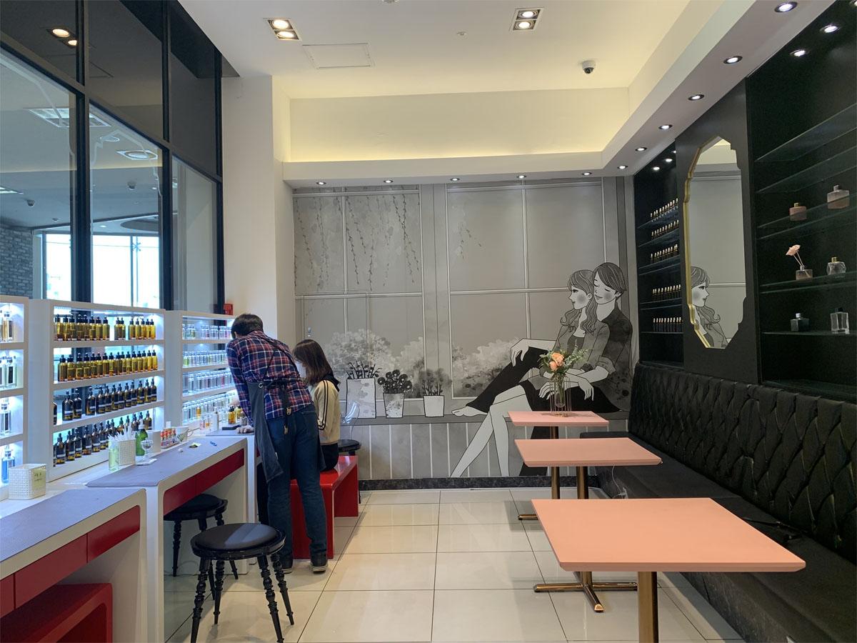 Внутренний интерьер магазина Aroma Forest с различными ароматическими бутылками на полке.