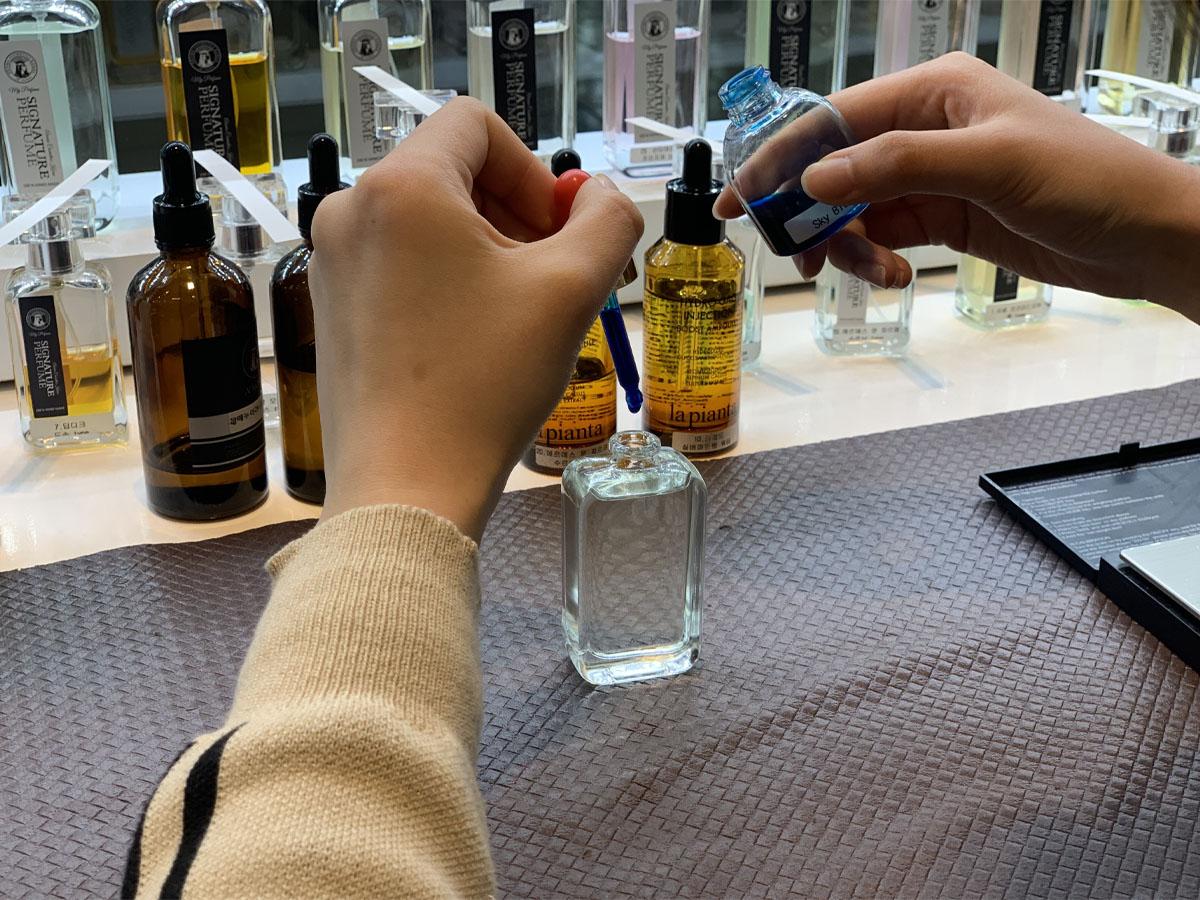 顧客在SCENT M.O.M.O.店內為香水瓶加入染料，進行最後調整