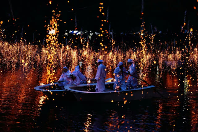 幻想的な夜空を背景に、韓国伝統の花火イベント「鹹安落火」の一瞬が美しく捉えられています。水面に落ちる火の光が華麗に輝く祭りの風景です。