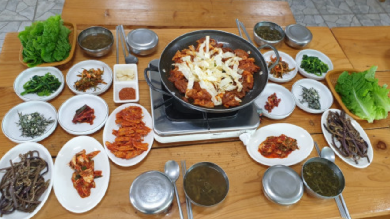 Gustoso pranzo tradizionale coreano con vari piatti di contorni di verdure e riso su un tavolo di legno