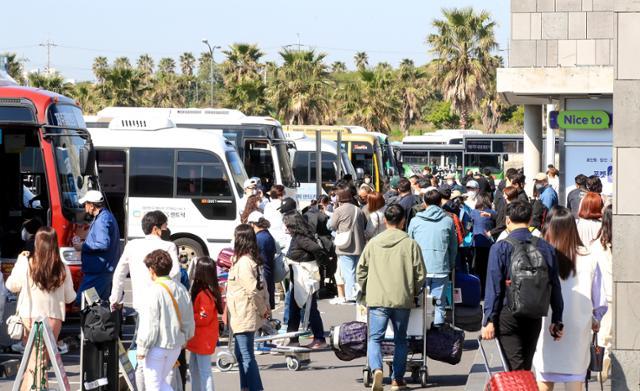 済州空港でバスに集まる外国人観光客の群集光景。6月からビザなし入国が再開され、多くの旅行者が訪れる。
