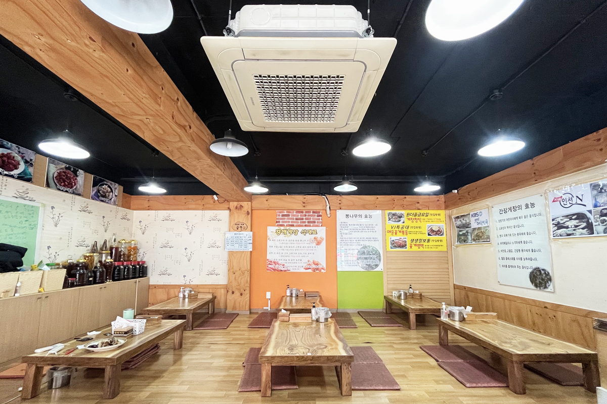 黄海酱蟹专卖店的内部装潢，突出复古氛围和传统韩式座位。