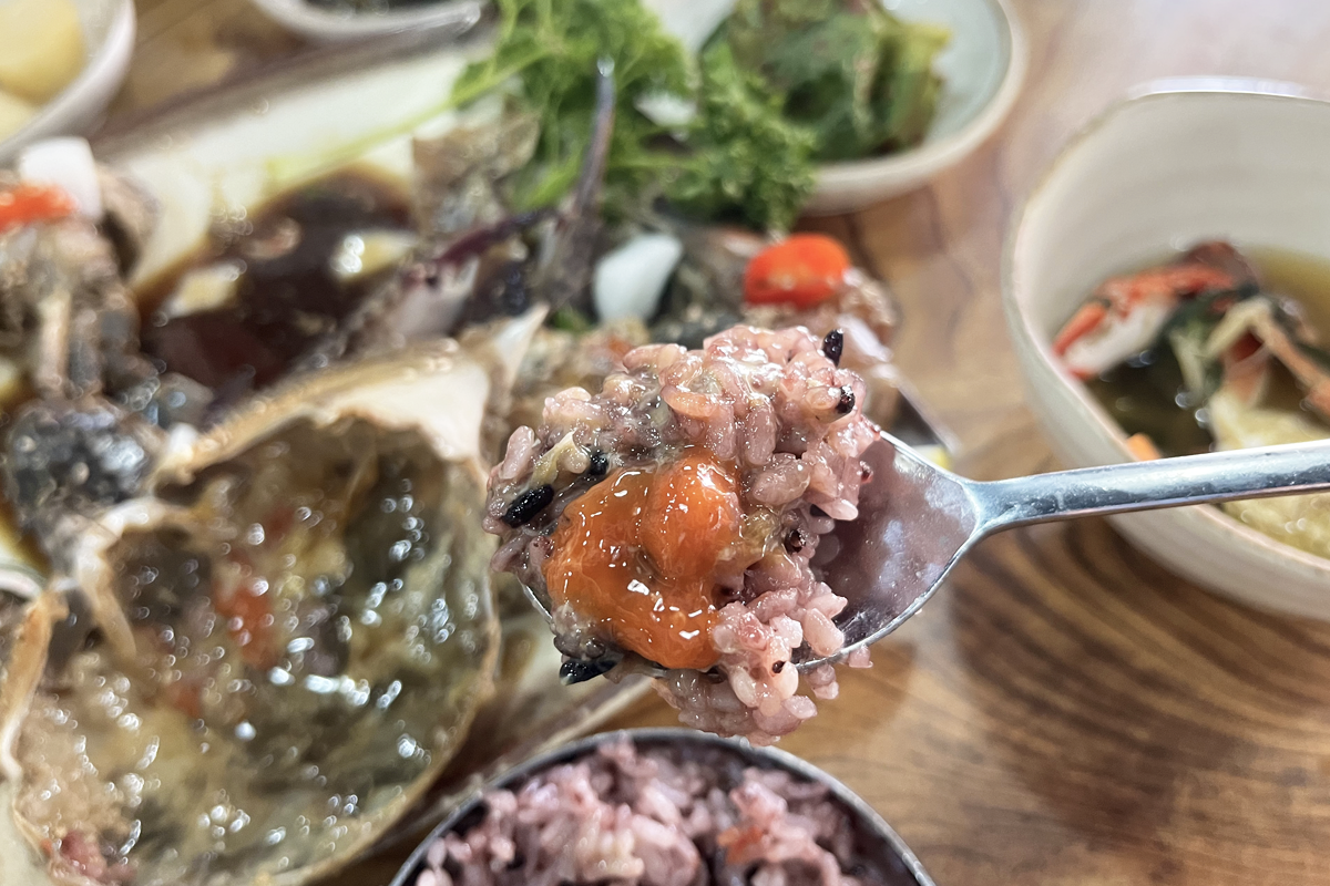 多样化的韩式小菜伴随酱蟹定食，展示韩国餐点的丰富和多样。