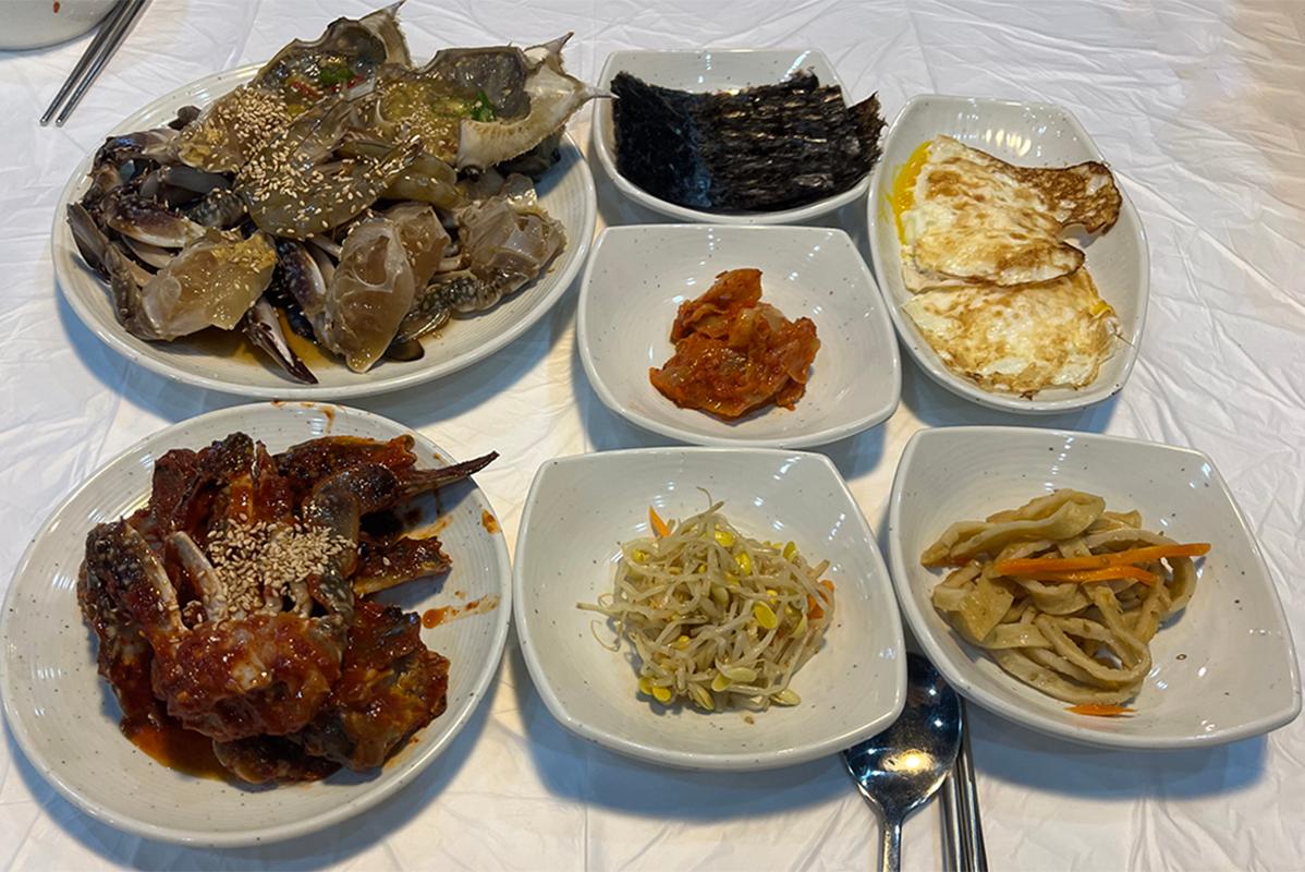 明贤万的延坪岛酱蟹的特色韩式餐点，展示多样美味配菜。