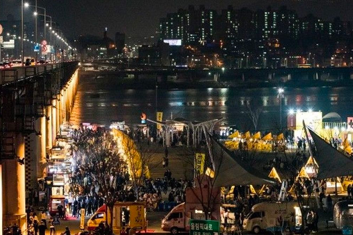 ハン川沿いに並ぶ色とりどりのテントが灯る夜の月光ナイトマーケット
