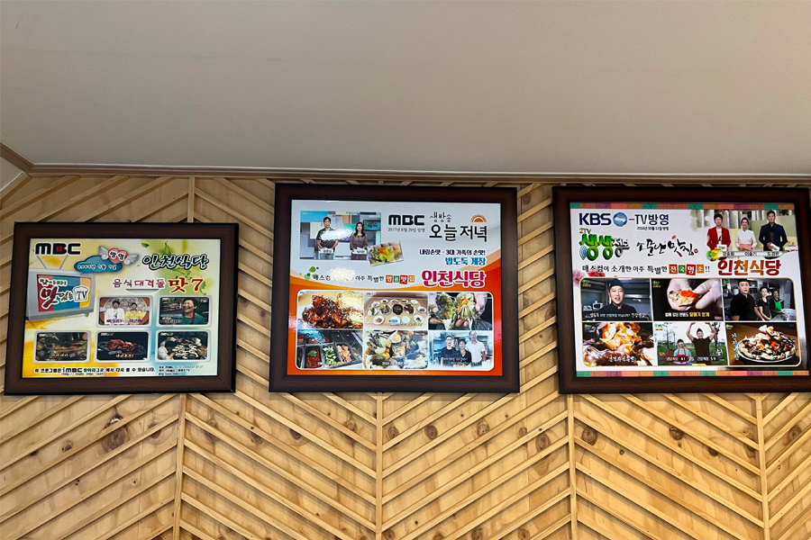 仁川三代醬蟹店內牆面展示了多個香名節目採訪與獎牌，顯示出餐廳受到了廣泛的媒體關注和專業認可。