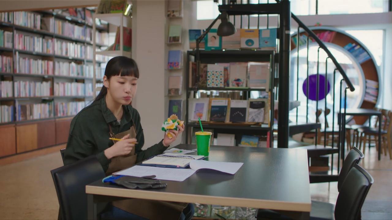 历史书房内,书架环绕四周,工作之余的女性正享受点心,构成复古而温馨的学习环境。