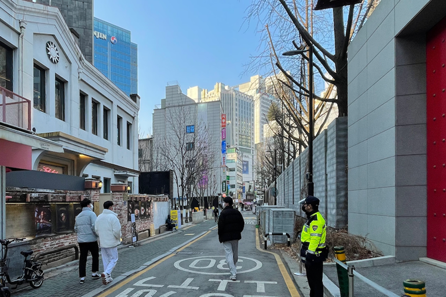 一名警察在街道上巡逻的图像，反映在韩国的台湾护照持有者与身份认同。