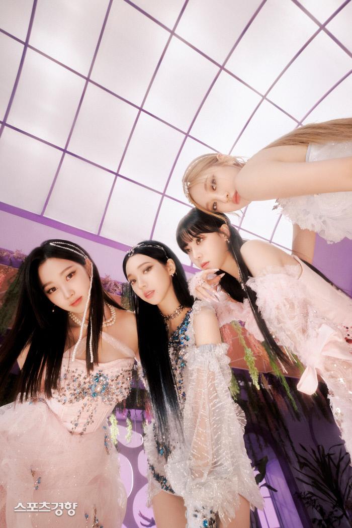 大きな窓の下でピンク色の衣装を着た女性たち