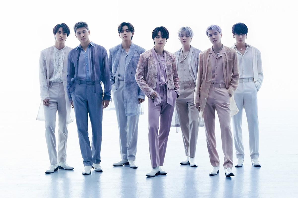 BTS ในการถ่ายภาพกลุ่มที่มีแสงสว่างสดใส สวมชุดสีอ่อนที่มีความโปร่งแสงในภาพบันทึกบรรยากาศการเฉลิมฉลองครบรอบ 9 ปีของพวกเขา