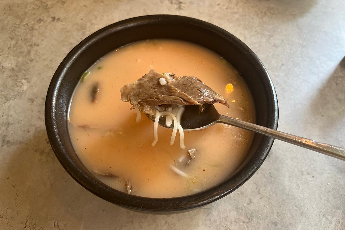 Rote Suppe nach Zugabe von Chilipaste zur traditionellen Seolleongtang im Lee Nam Jang