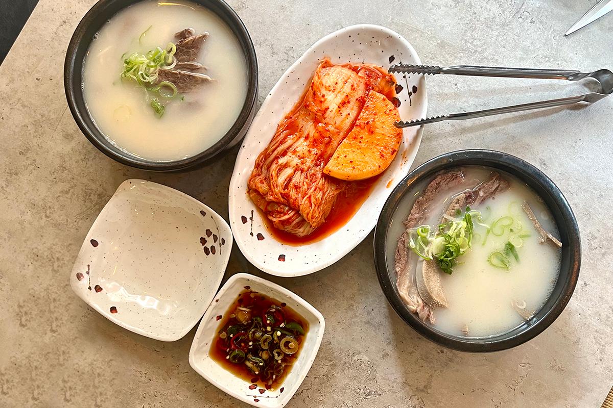 Bestellung von Seolleongtang mit Kimchi und Dip-Sauce auf dem Tisch im Lee Nam Jang