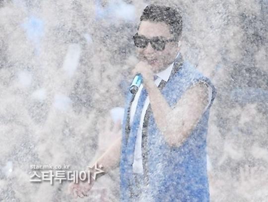 ステージ上で水しぶきを浴びながらパフォーマンスをするアーティスト