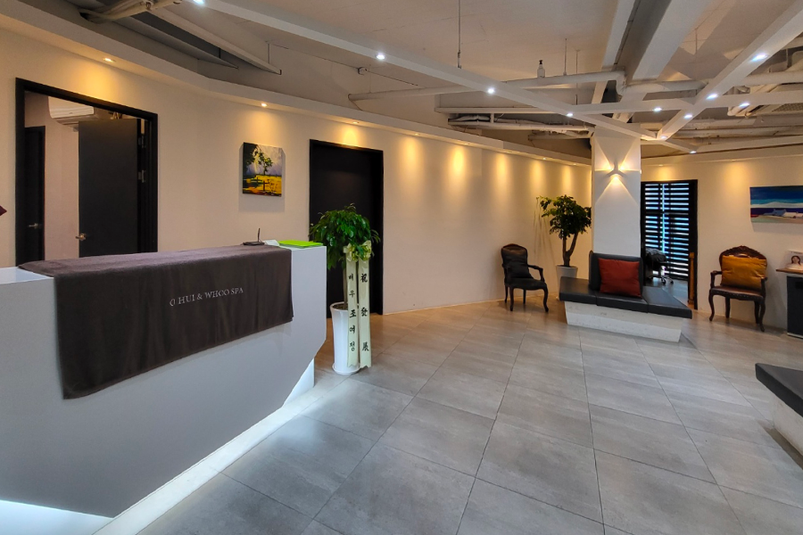 Ohui & Whoo Spa 接待櫃檯，擺放著植物，牆上掛著畫作，營造溫馨舒適的氣氛。