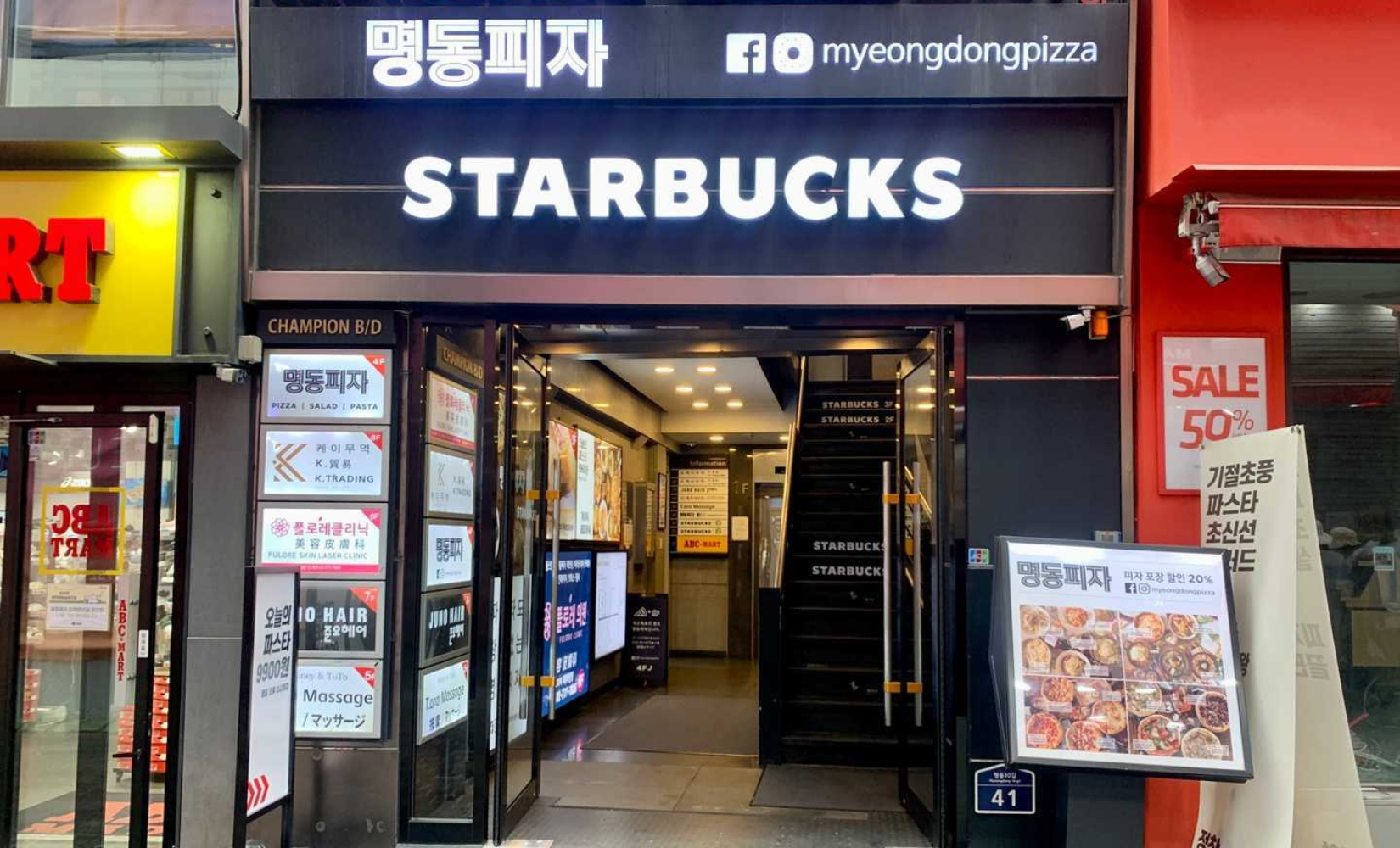 Busy street in Myeongdong near a well-known Starbucks, a popular area for shopping in Seoul.