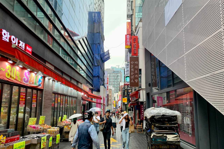 沿著 Olive Young 巷子步行的街景，兩旁有商店和招牌。