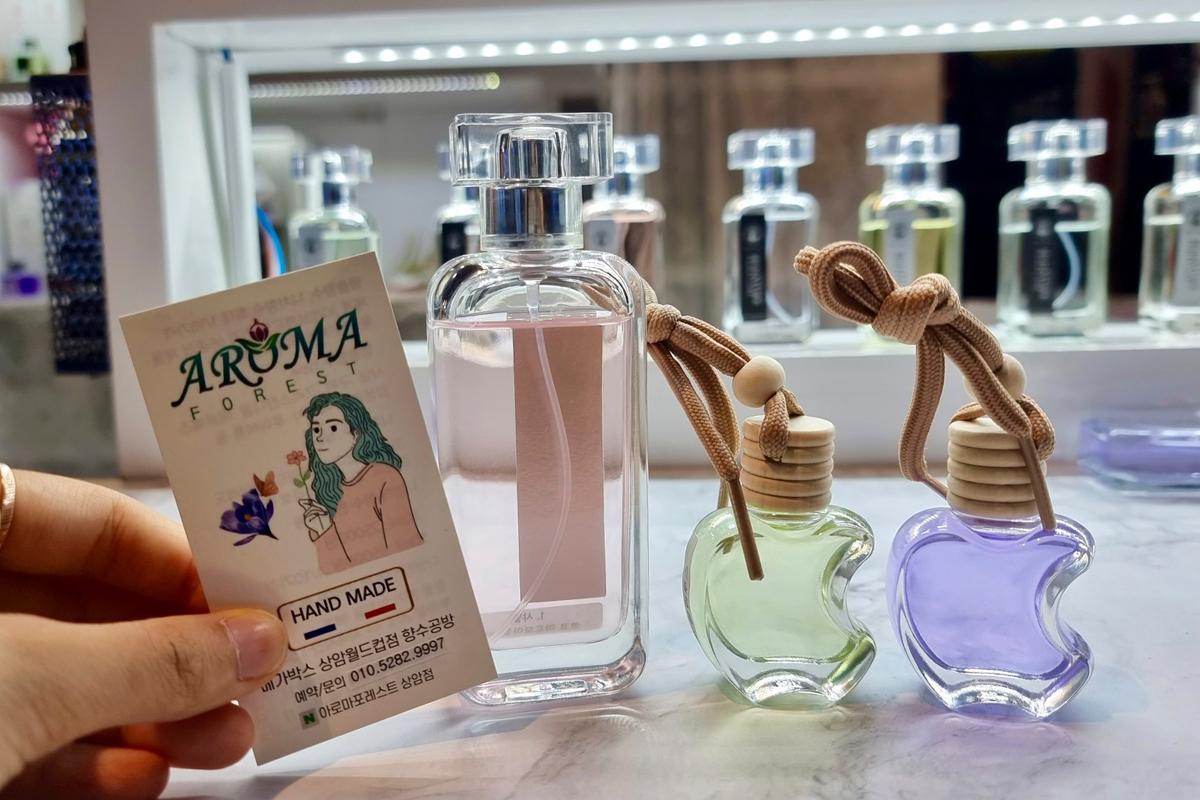 Бутылка с духами и два портативных ароматических флакона в форме яблока в Aroma Forest.