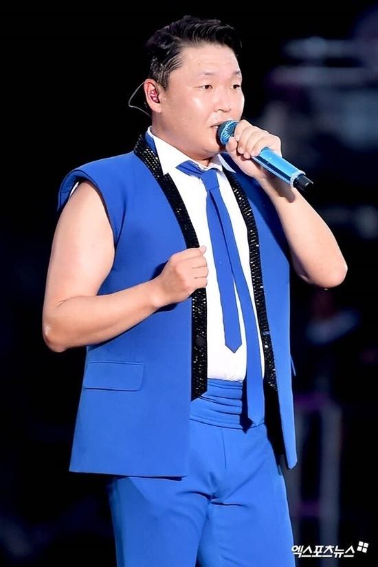 PSYのコンサート「びっしょりショー」の舞台で青い衣装を着てマイクを持つ歌手の姿