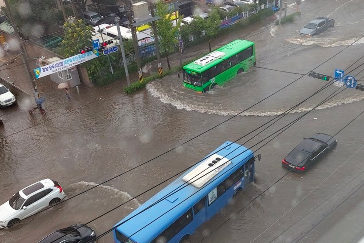首爾江南區在暴雨中出現的交通擁堵情況，公交車和汽車在積水中行駛。