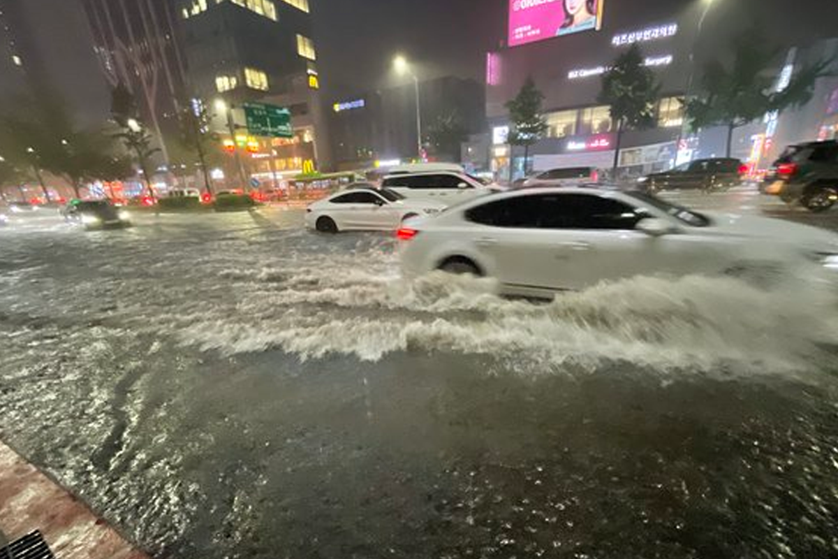 暴雨引發的首爾江南區的洪水狀況，顯示汽車在積水中行駛的挑戰。
