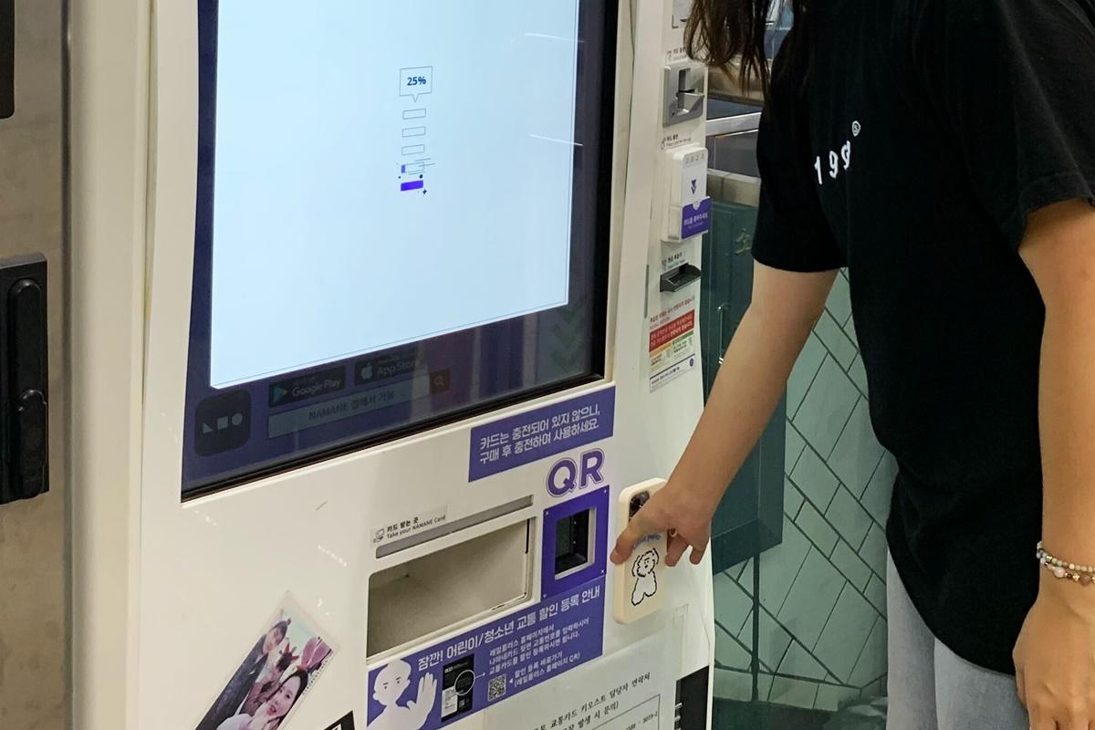 Person using a touchscreen interface on the NAMANE card kiosk to process a transaction.