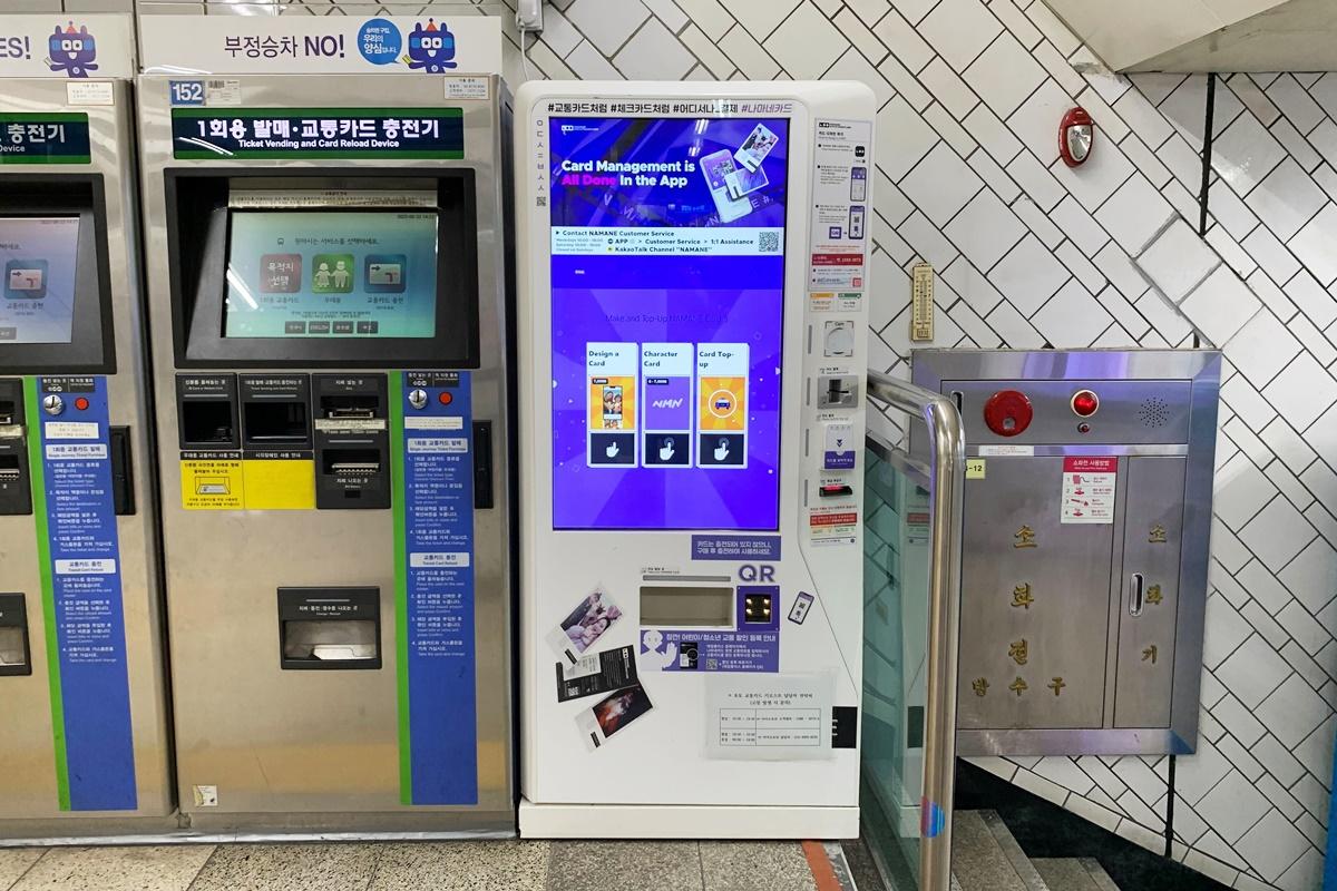 NAMANE card kiosk machine located in a transportation area with bold graphical instructions.