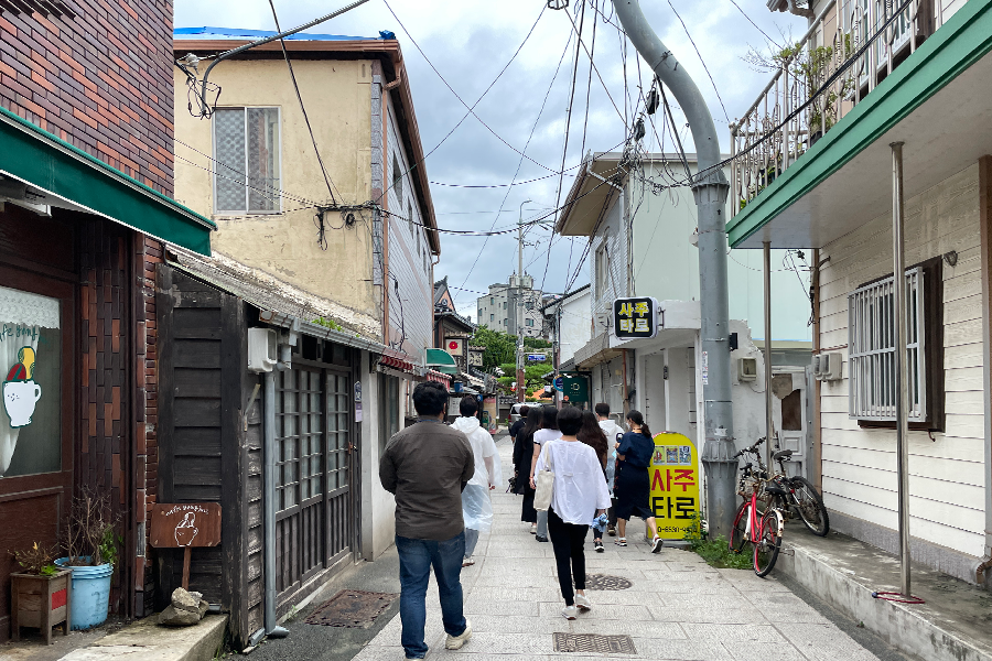 在九龍浦街道上分析日式建築，延續《山茶花開時》中展現的古代建築風格。