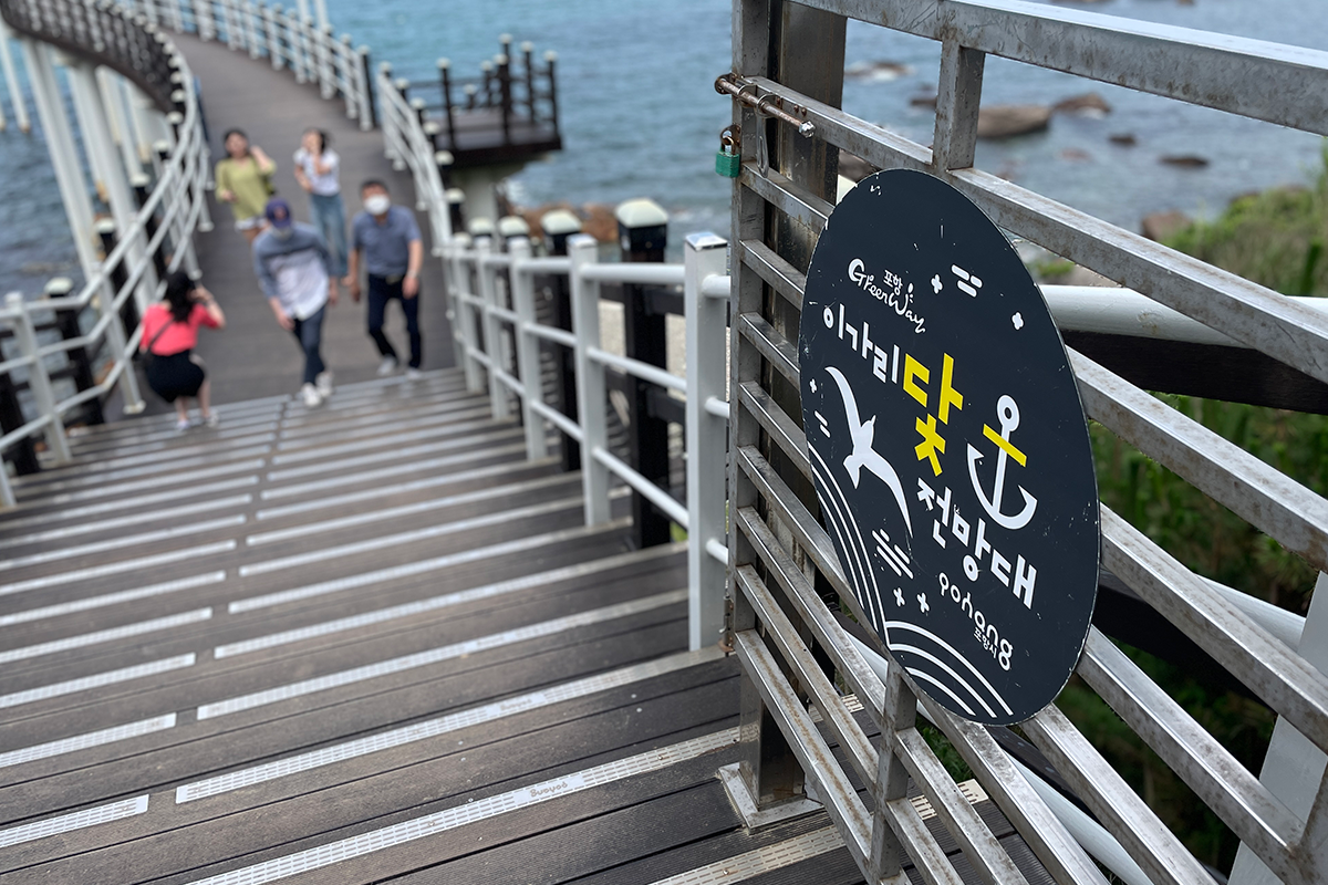 展望臺的利用規則告示牌，背後是波光粼粼的海面。