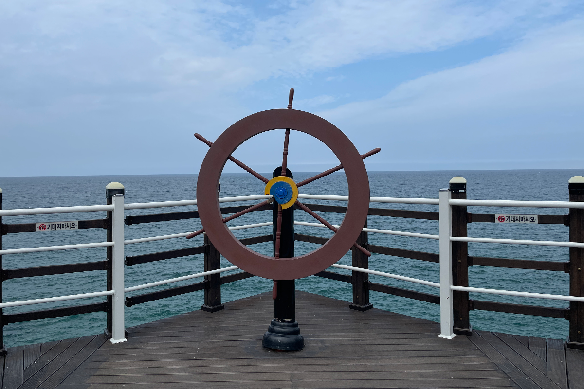 建築內部窗口，框住遠方海岸線，充滿寧靜之美。