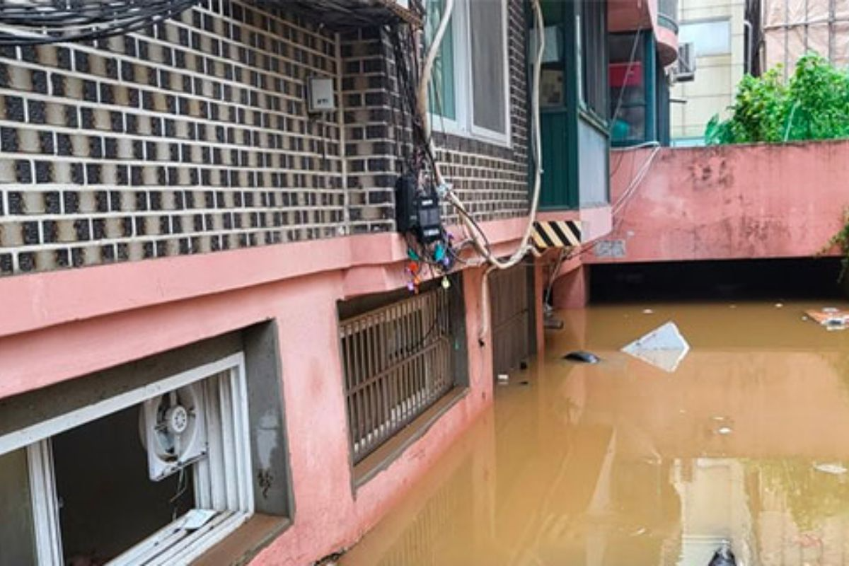 Cảnh lụt bên ngoài một căn nhà bán hầm tại Seoul, nước ngập che khuất phần lớn bức tường dưới.