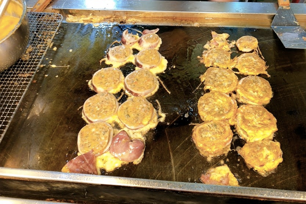 韓國市場上的魷魚血腸，熟食煎臺上的近拍，具代表性的韓國街頭小吃，在江陵中央市場廣受歡迎。