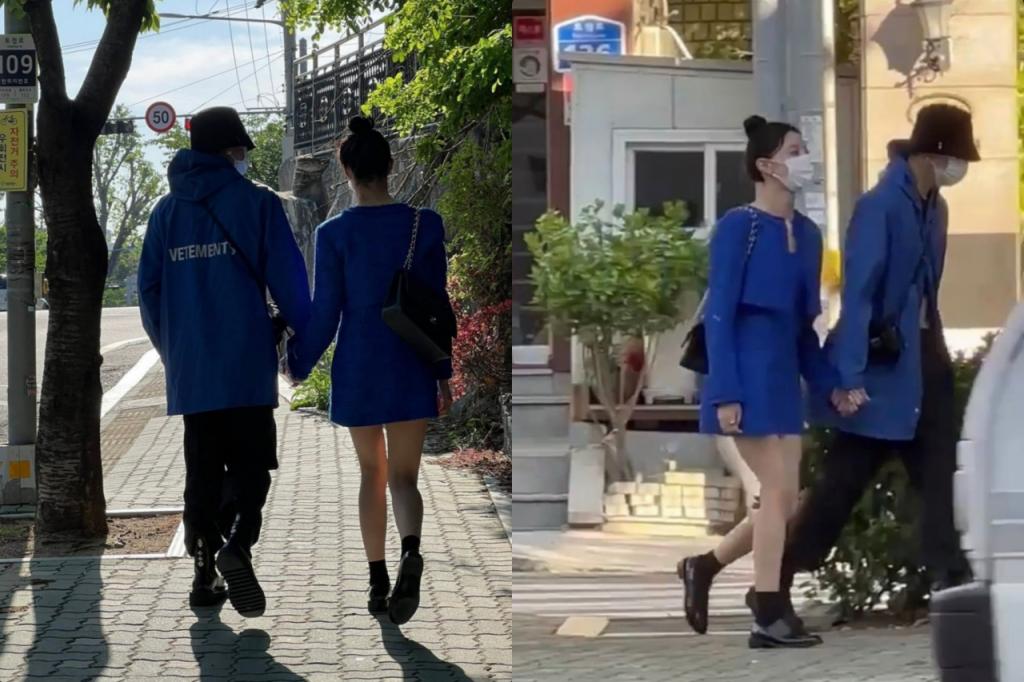 通りを歩く2人の人が青いコートを着て手を繋いでいるところの写真。男性は青いベトメントのジャケットを着て、女性は同じく青いドレスを着ている。