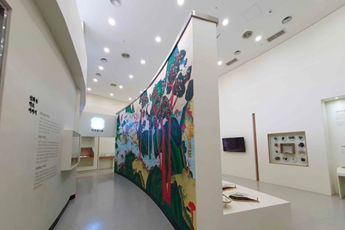 东医韩方村内展示区，墙面装饰有传统艺术作品，灯光柔和，氛围雅致。