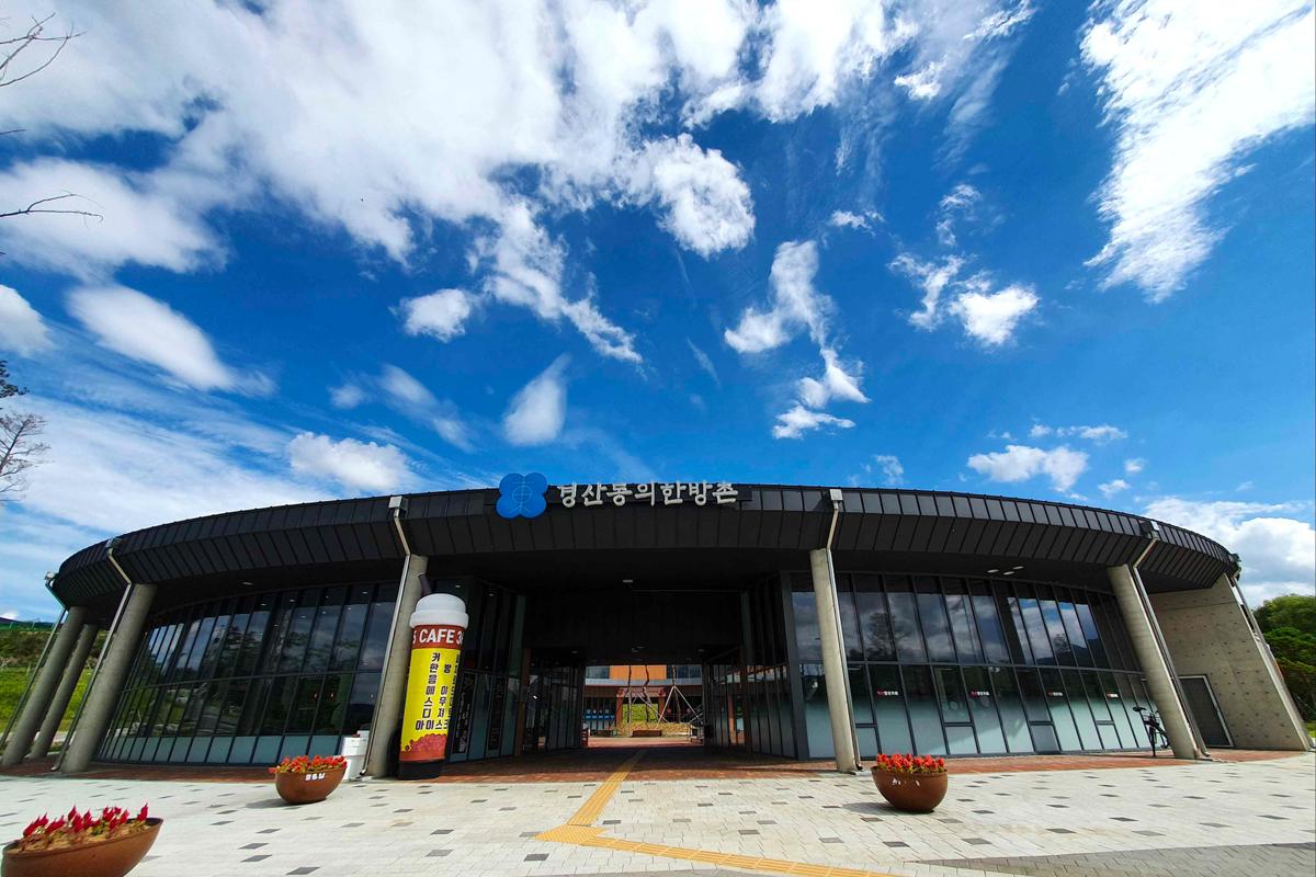 东医韩方村入口，现代建筑与自然景观完美结合，可见馆名标牌。