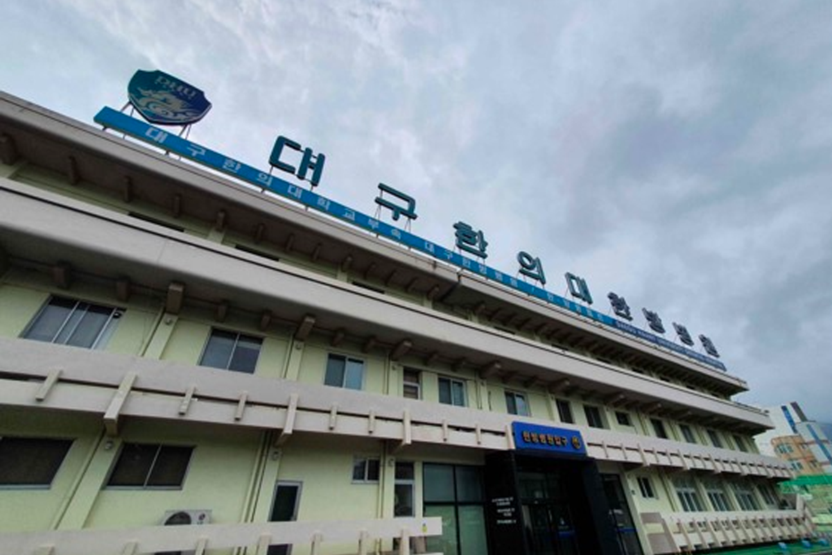 大邱韩医大学正面外观，天气阴沉，建筑物顶部展示校名与标记。