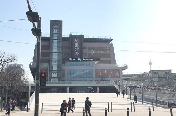 首爾世運商街外觀，這裡是韓國最早的電子綜合市場之一。圖片拍攝於晴天，右側可以看到遠處的首爾塔。