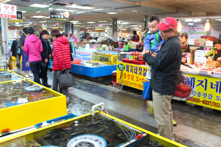 客人們在束草觀光水產市場選購海鮮的場景