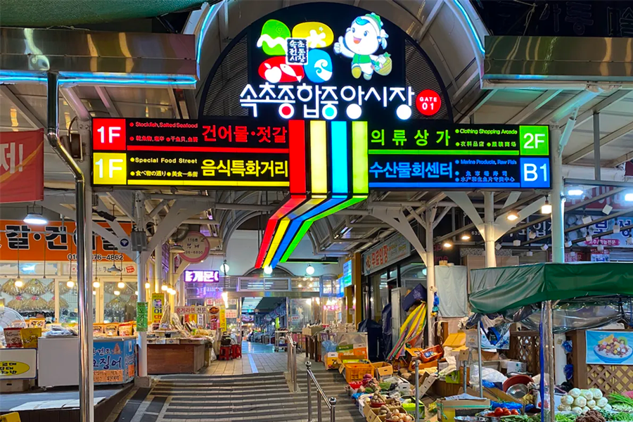 韓國束草觀光水產市場內，五顏六色的招牌和海鮮攤位