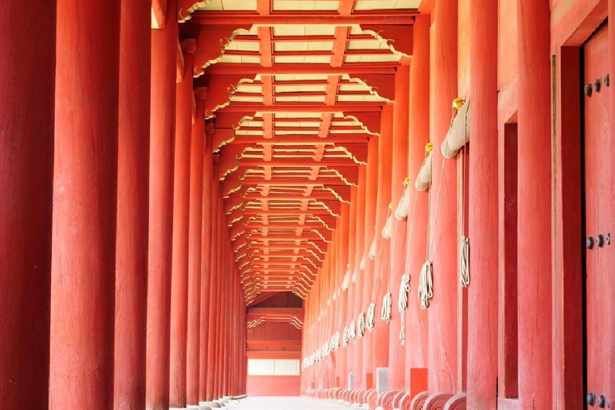 Foto del Santuario Jongmyo en Seúl, Corea del Sur, que muestra una fila de columnas rojas en un pasillo histórico bien conservado, parte del Patrimonio Mundial de la UNESCO.