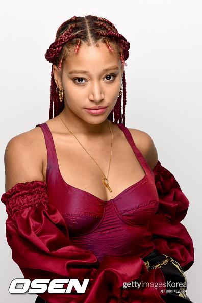 赤いドレスを着た女優がポーズを取る画像