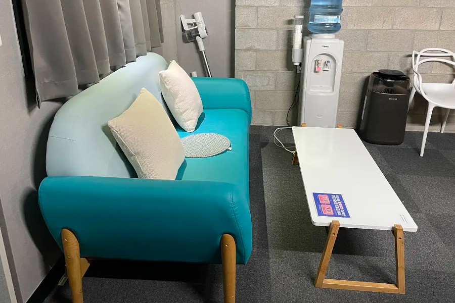 音乐录音室外的休息区,设有舒适的沙发和桌椅,供等待录音的参与者放松休息。